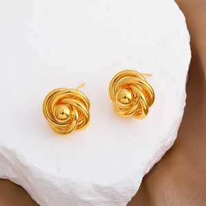 French retro 18k gold plated knotted stud earrings on a white stone background