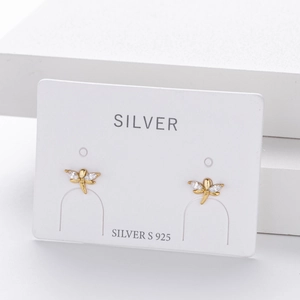 Macro shot of gold S925 sterling silver dragonfly stud earrings with sparkling crystals