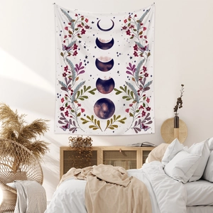 Detail of bohemian moon phase tapestry with floral patterns and butterflies on bedroom wall
