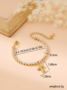 Close-up of gold cross pendant tennis bracelet with cubic zirconia and extension chain
