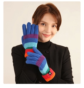Detailed studio shot of rainbow striped knit gloves showing soft texture on a model