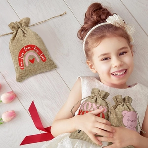 Close-up of linen drawstring gift bags with heart and love prints in a cozy setting