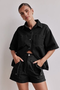 Detail eines schwarz gewaschenen Denim-Sets mit Hemd und Cargo-Shorts sowie Texturdetails