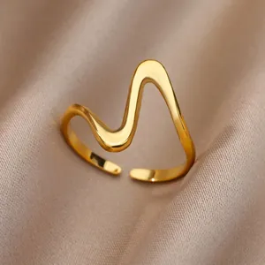 Macro detail of gold wavy open ring with high-polished finish on silk fabric background