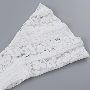 Close-up of white lace dress showing intricate crochet patterns and floral embroidery
