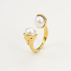 Detailed view of a gold open ring featuring two elegant white pearls on a white background