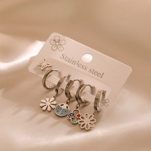Macro shot of stainless steel earring set with colorful butterfly and floral charms
