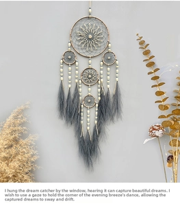 Detail of bohemian dream catcher featuring multi-tier rings and grey feather tassels