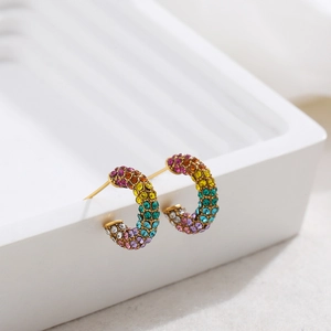 Close-up of gold-plated C-shape earrings with colorful pavé-set rainbow zircons