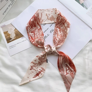 Detail view of a vintage cream twilly silk scarf with brown floral patterns and letter A