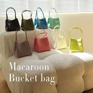 Borse a secchiello Macaron in pelle PU multicolore su un divano bianco soffice