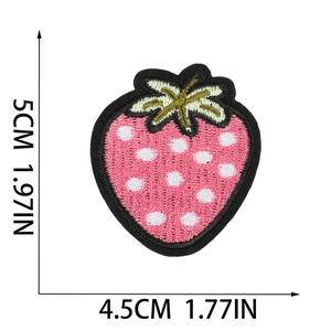 Detailed view of pink strawberry embroidery patch with white dots and green leaves