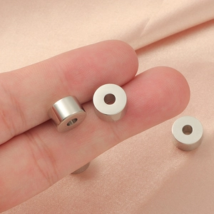 Polished silver cylinder spacer beads for DIY jewelry making shown in a macro view