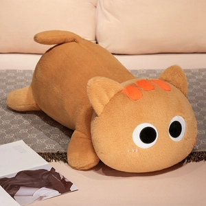 Detail of cute orange plush cat toy with big eyes on cozy blanket for home decor