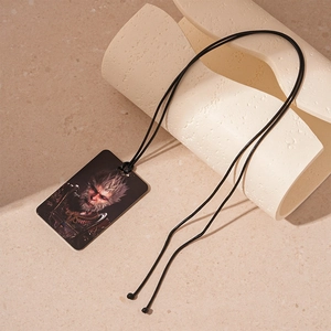 Detail of square stainless steel necklace featuring a dark game character print on a cord