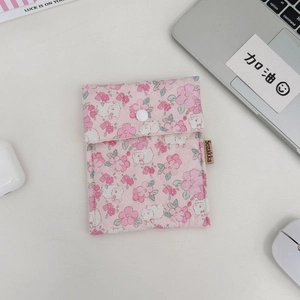 Detailansicht der rosa geblümten gesteppten Aufbewahrungstasche mit Druckknopf auf dem Tisch