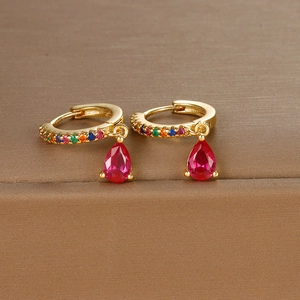 Detail of gold hoop earrings with rainbow pavé stones and red pear-cut zircon drop pendants