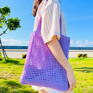Outdoor shot of a purple hollow knit mesh tote bag with a minimalist shoulder design
