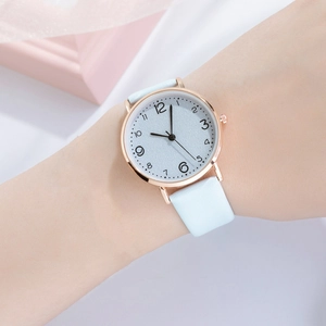 Close-up of light blue leather strap and rose gold case on women's quartz watch
