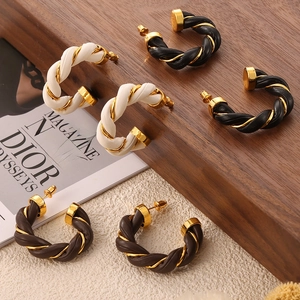 Three pairs of vintage leather-wrapped twisted C-shaped earrings in white, black, and coffee
