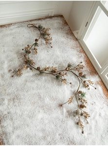 Détail de pommes de pin dorées, baies et feuilles sur un fond en bois enneigé festif