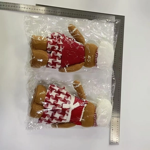 Detailed view of plush gingerbread man dolls in red dress with measurement ruler display
