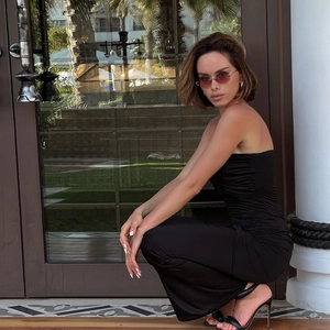 Detail showing backless black bodycon tube maxi dress with side ruching on model