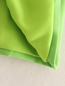 Close-up of vibrant lime green woven fabric showing fine stitching and premium texture