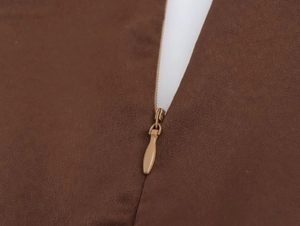 Detail view of a hidden brown zipper on elegant chiffon dress with smooth metal teeth