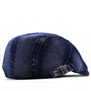 Detailed side view of dark blue denim ivy cap featuring adjustable bronze buckle
