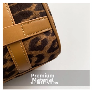 Close-up of leopard print suede fabric with brown leather trim and yellow stitching