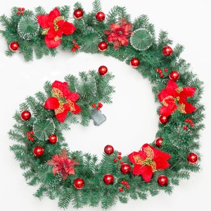 Macro shot of 9ft Christmas garland with red poinsettias berries and pine needles