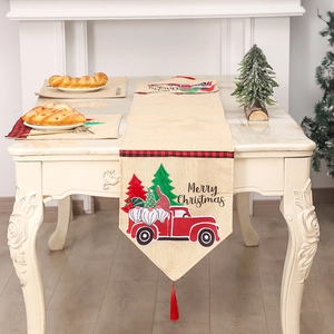 Christmas table runner with red vintage truck and gnome pattern on beige linen cloth