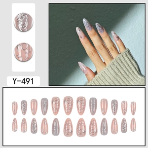 Elegant long almond press-on nails in nude pink and grey with silver starburst patterns
