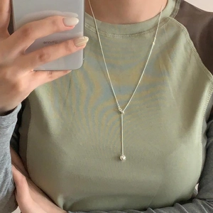 Detailed view of silver heart lariat necklace with adjustable sliding clasp on skin