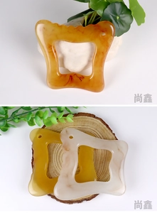 Detail of butterfly resin gua sha tools with amber marble texture on wooden base