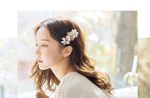 Side view of a woman wearing a handmade floral hair clip with pink and beige flowers