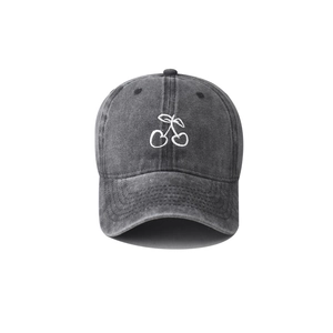 Close-up of embroidered white cherry logo on washed cotton vintage baseball cap