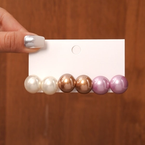 Detail view of a six-piece set featuring pearl stud earrings in three distinct colors