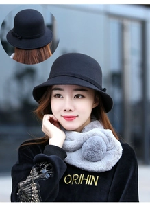 Dettaglio cappello a cloche in lana nera con fiocco e sciarpa in pelliccia sintetica grigia