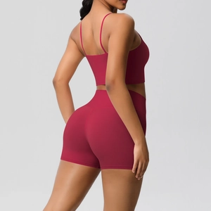Detail of red yoga set showing slim-fit strappy sports tank top and high-waist shorts