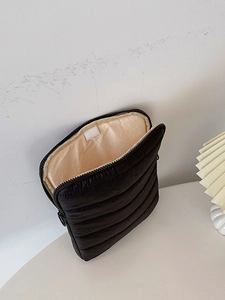 Black quilted laptop sleeve with champagne lining and velcro closure in open view