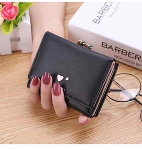 Close-up of black bi-color trifold wallet featuring heart-shaped hardware and fine texture