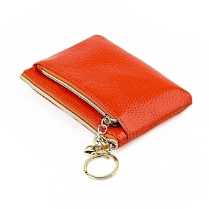 Detail of orange genuine leather coin purse with double zippers and gold heart keychain
