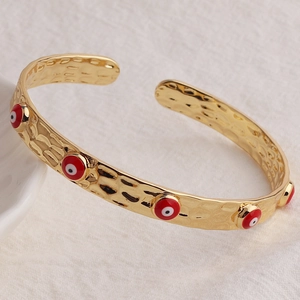 Bracciale rigido martellato placcato oro 18K con ciondoli a occhio in smalto rosso
