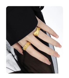 Detail of gold matte brushed rings with inlaid zircon stones on woman hand