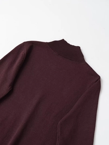 Detailed close-up of the burgundy fine knit turtleneck with ribbed neckline stitching
