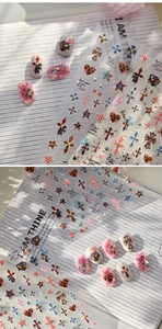 Detail showing vintage cross and leopard print nail stickers on beige false nails