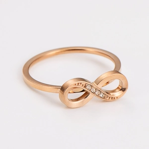 Macro detail of rose gold infinity ring featuring delicate pavé-set zircons on the band