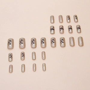 Sparkling champagne gold glitter square press-on nails with black stars and magic text